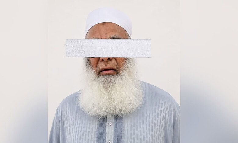 Man with a white beard and traditional white cap, eyes covered with a white strip.