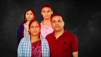 Family portrait of four people against a dark background, including two women and two men.