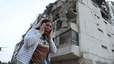 Woman distressed near damaged building after Venezuela earthquake, 2023.