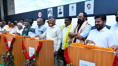 Indian political leaders at a public event, standing behind decorated podiums with floral arrangements.