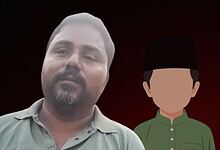 Photograph of a man with a beard and a young boy in traditional attire against a dark background.