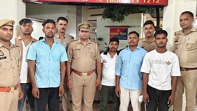 Group of police officers and civilians standing outside a building in India.