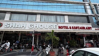 Shah Gouse Hotel & Restaurant building with parked motorcycles and pedestrians outside.