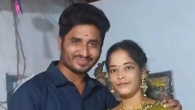 Smiling pregnant woman with her husband in a home setting.