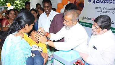 Damodar Rajanarsimha administers polio drops to a child