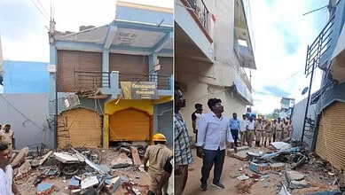 Collapsed commercial building in Raichur with rescue workers and onlookers present.