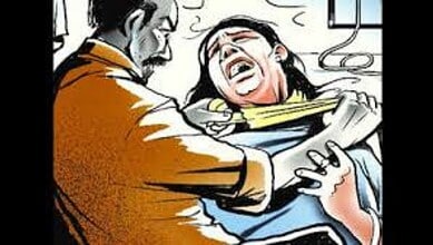 A woman in distress being attended to by a man in a hospital setting.