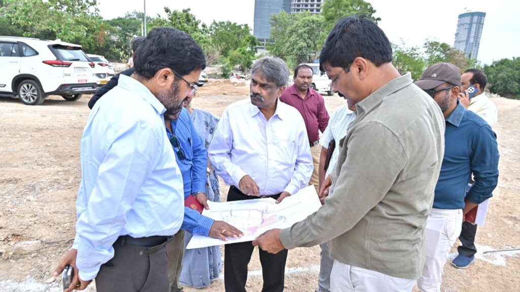Group of officials reviewing plans at Hyderabad water board site under clear sky.