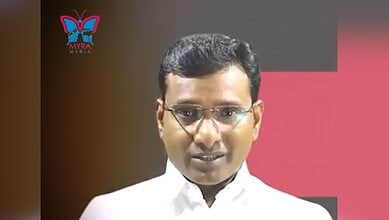 Hyderabad-based journalist KV Reddy in a white shirt and glasses during a public appearance.
