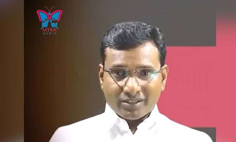 Hyderabad-based journalist KV Reddy in a white shirt and glasses during a public appearance.