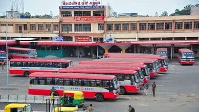 KSRTC bus station with multiple red and white buses parked in a lot.