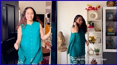 A woman in a turquoise dress smiling and walking indoors; another woman in a similar dress standing near.