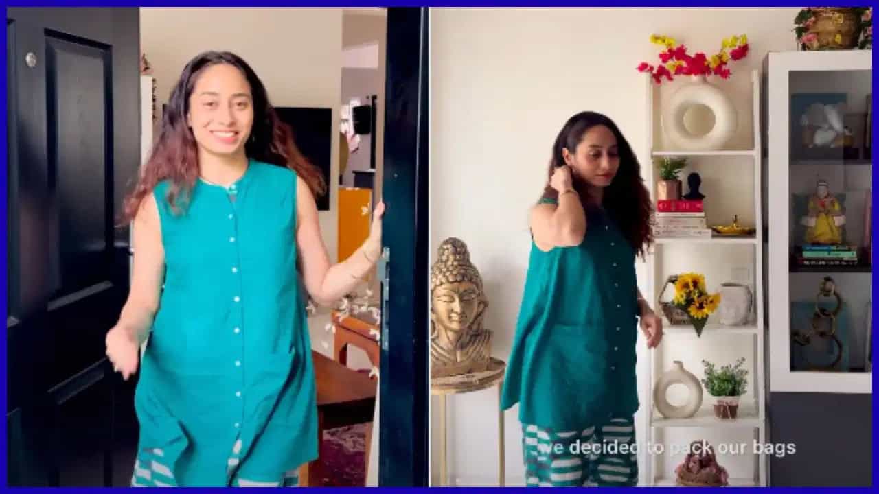 A woman in a turquoise dress smiling and walking indoors; another woman in a similar dress standing near.