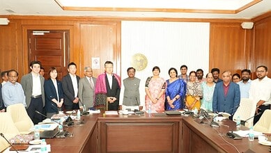 A diverse group of professionals gathered in a conference room for a formal meeting at The Siasat Daily.