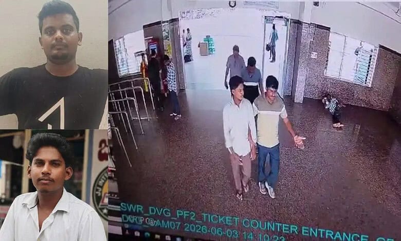 A man standing at the ticket counter entrance of a public building, with other people walking in and out.
