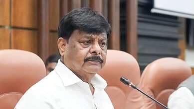 H.C. Mahadevappa during a formal meeting or hearing, serious expression, in a professional setting.
