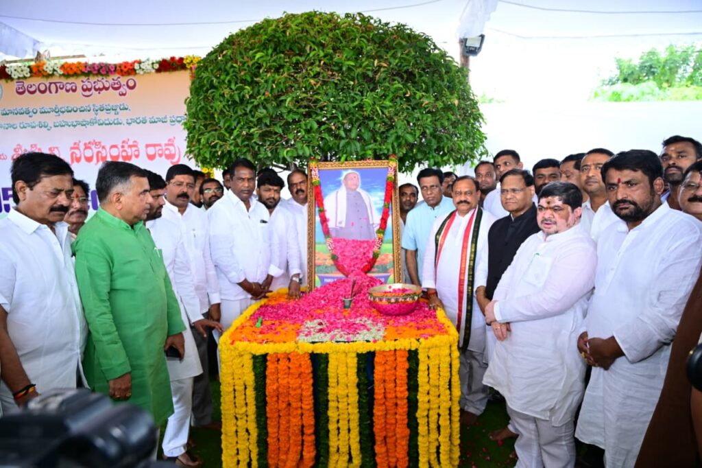 People gather around a floral tribute to PV Narasimha Rao during his birth anniversary in Hyderabad.
