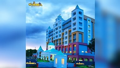 Colourful Wonderla resort building with blue sky and clouds in the background.