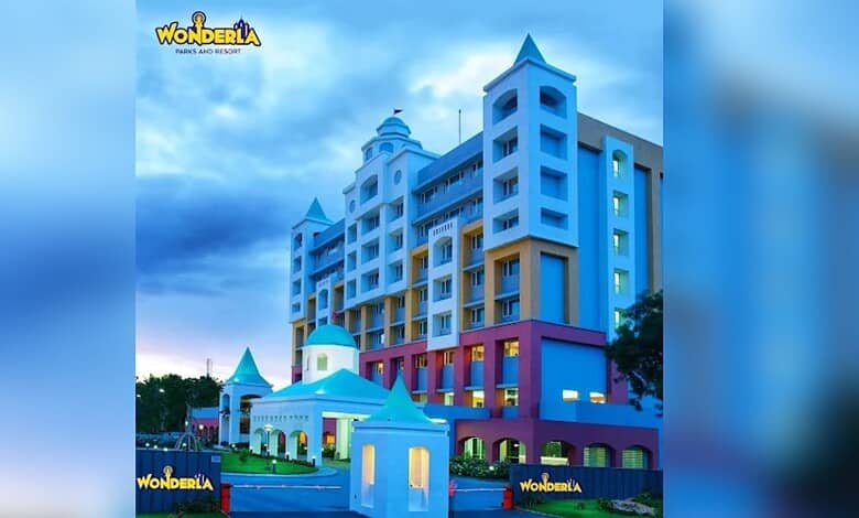 Colourful Wonderla resort building with blue sky and clouds in the background.