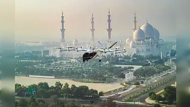 F-16 fighter jet flying over Dubai's iconic mosque with minarets and domes in the background.