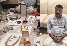 Antique silver jewelry displayed on a table with a man sitting on a sofa in the background.