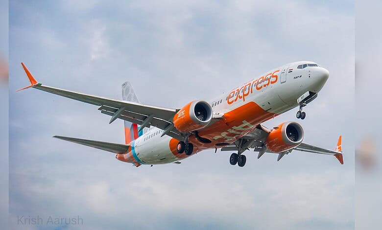 Airplane in flight with orange and white livery, under a cloudy sky, promoting new flight route.