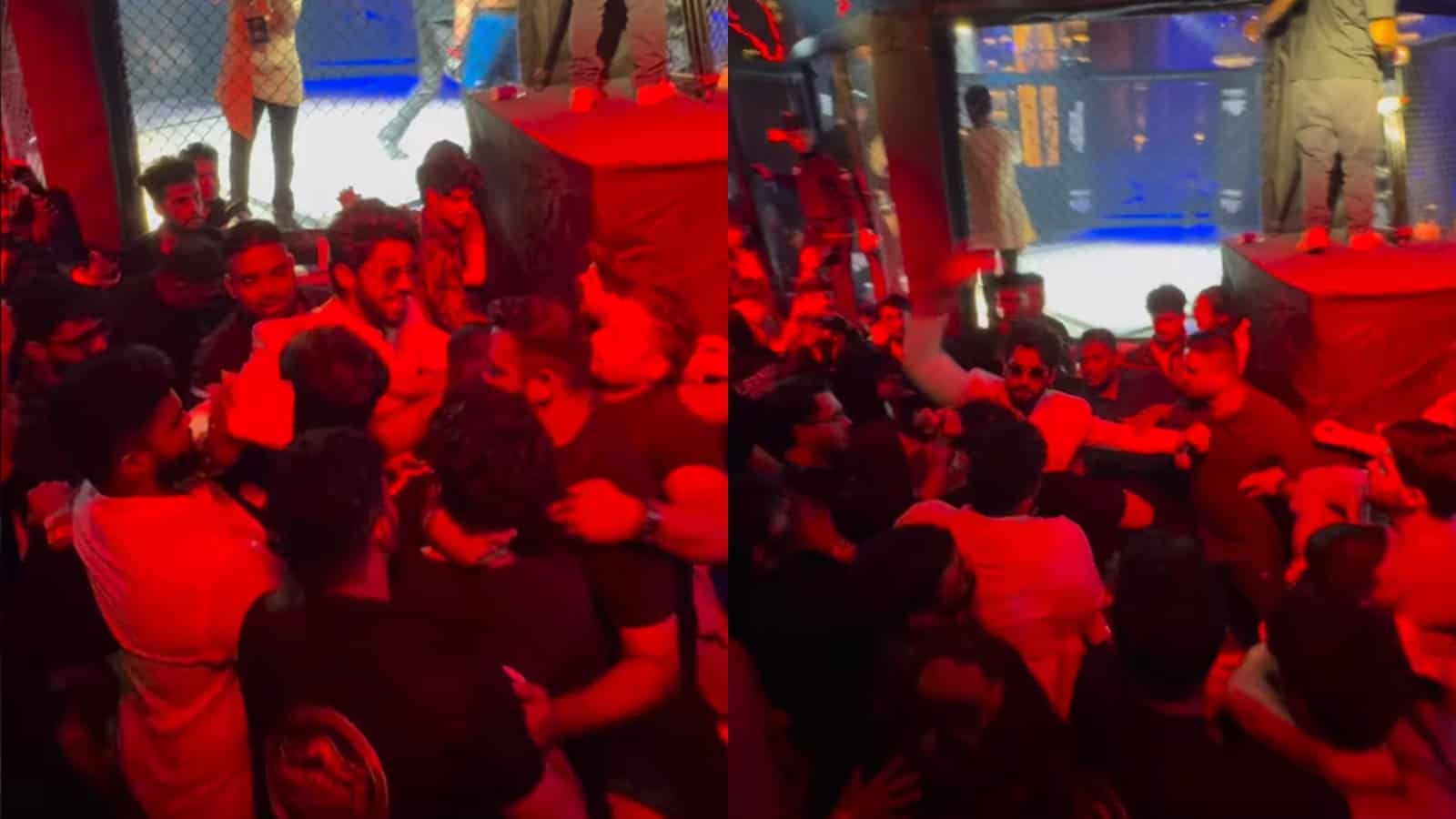 A group of people gathered at an indoor event with a stage and large screen, engaging in conversation and.