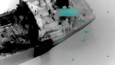 Aerial view showing a commercial vessel targeted during a reported US military strike in the Gulf of Oman.