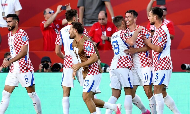 Croatian football players celebrating during a match, wearing checkered jerseys, in a stadium.