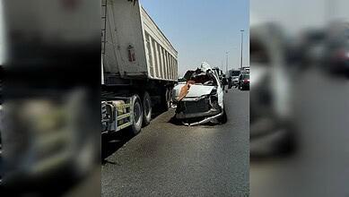 A severely damaged minibus after colliding with a stationary truck on Emirates Road in Dubai.