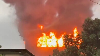 Fire outbreak in a forest with large flames and dense smoke, highlighting environmental hazards.