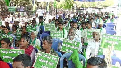 Protest rally with diverse crowd holding green placards in an outdoor setting for social or political cau.
