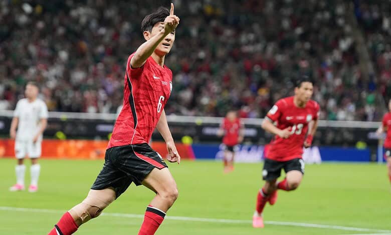 Football player in red jersey celebrating a goal on the field during a match.