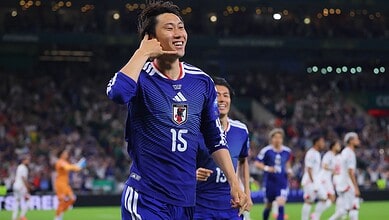 Japanese football player celebrating after scoring a goal during a match.