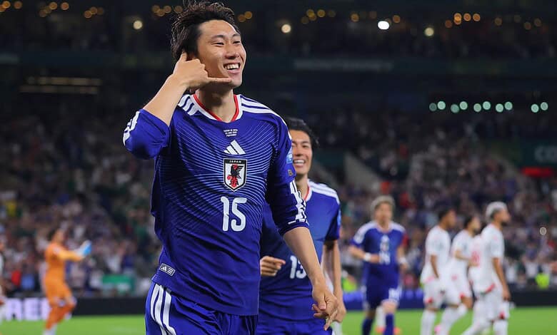 Japanese football player celebrating after scoring a goal during a match.