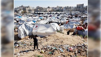 Overcrowded Gaza displacement camp with tents and poor sanitation conditions.