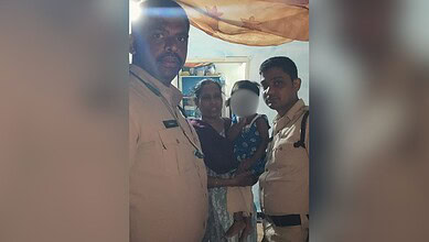Police officers with a woman and child in a community setting.