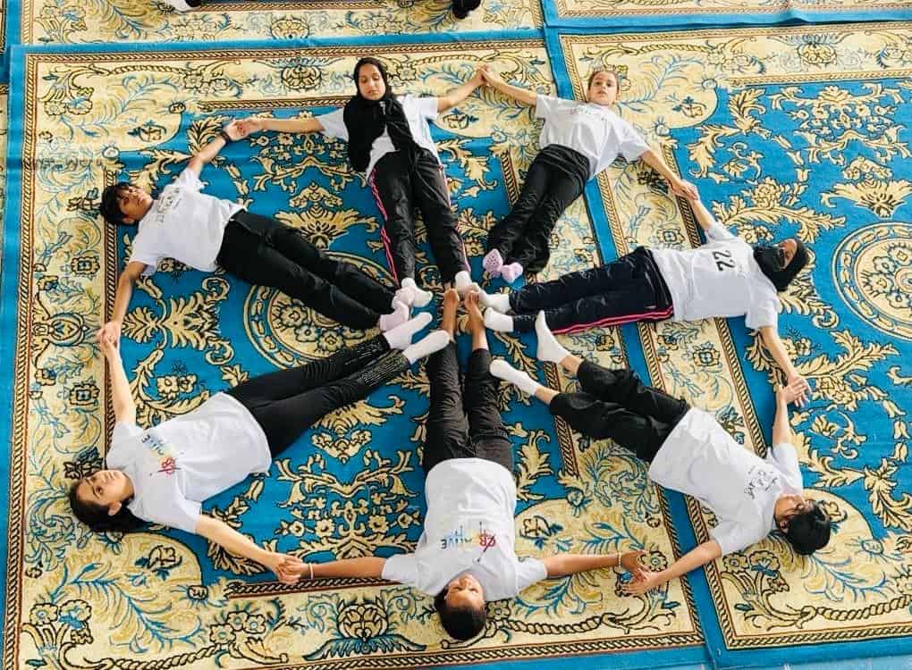 Students perform a group yoga activity during IDY 2026 celebrations in Abha.