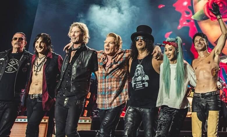 Vibrant rock band performing live on stage with energetic members and colourful lighting.