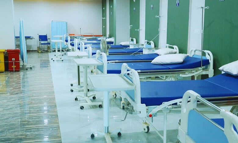 A hospital ward with empty beds and medical equipment, ready for patients.