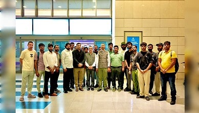 A diverse group of young men and women standing together at an airport terminal, smiling and posing for a.