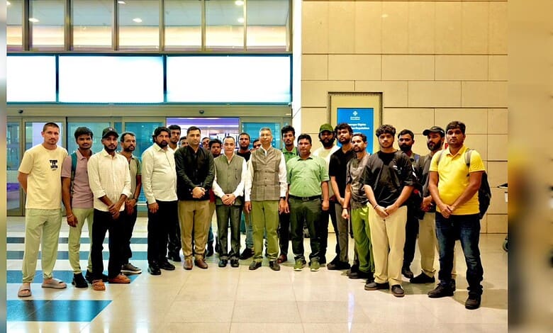 A diverse group of young men and women standing together at an airport terminal, smiling and posing for a.