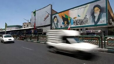 Vehicles pass a mural of Ayatollah Ruhollah Khomeini and Ayatollah Ali Khamenei on a street in Tehran, Iran.
