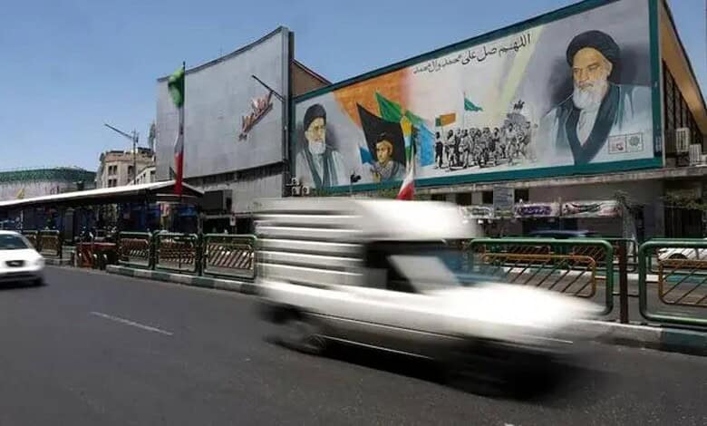 Vehicles pass a mural of Ayatollah Ruhollah Khomeini and Ayatollah Ali Khamenei on a street in Tehran, Iran.
