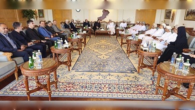 Iran and Oman officials meet in a formal conference room for joint committee discussions.