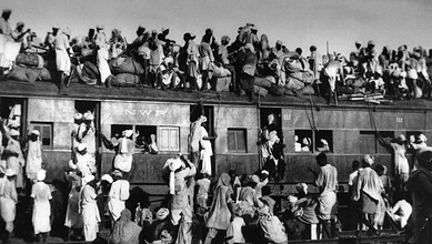 Mass migration during India's Partition in 1947 with people crossing trains and carrying belongings.