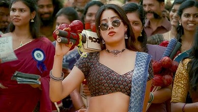 A woman holding a red apple and a traditional weapon during a cultural event in a crowd.