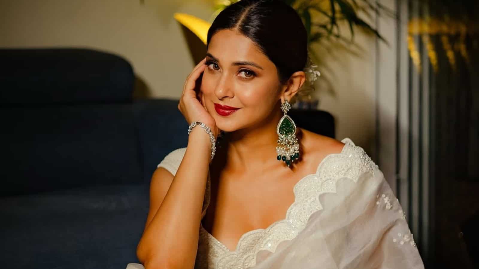 Elegant woman wearing traditional attire and jewellery, smiling confidently at The Siasat Daily event.