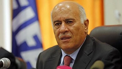 Senior politician addressing media during official event in formal setting.