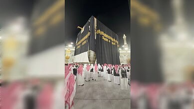 The Kaaba in Makkah draped with a newly installed Kiswah marking the Islamic New Year 1448 AH, as workers and worshippers gather in the Grand Mosque at night.